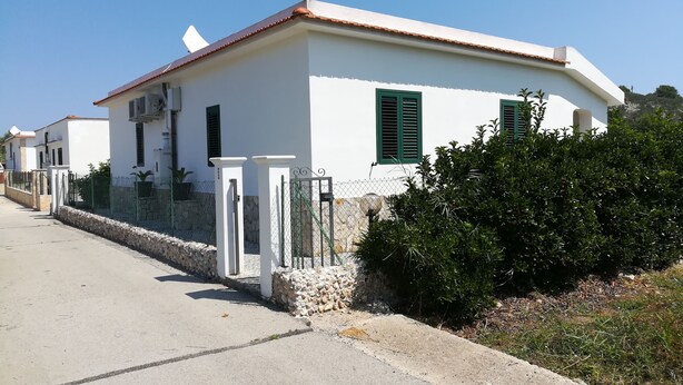 A white building with green shutters, a stone wall, and a metal gate. - Holidays in Vieste in Charming Villas - 2 (Vieste)