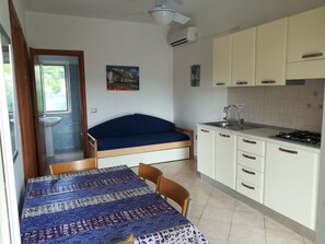 A compact room with a bed, a small kitchenette, a sink, and a window. - Holidays in Vieste in Charming Villas - 2 (Vieste)