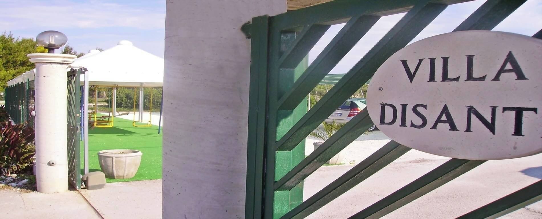 A sign reading "VILLA DISANT" at the entrance of a property.