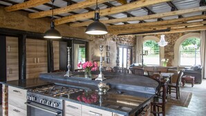 A spacious kitchen with a large island, built-in oven, and modern cabinetry.