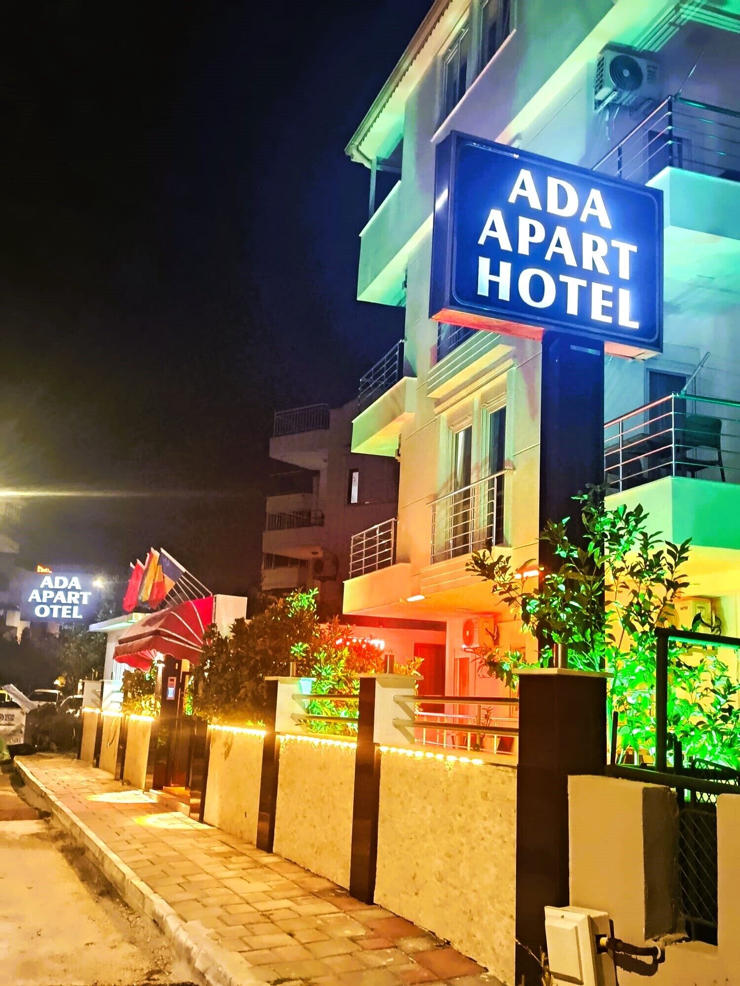 A building with a sign reading 'ADA APART HOTEL' at night.