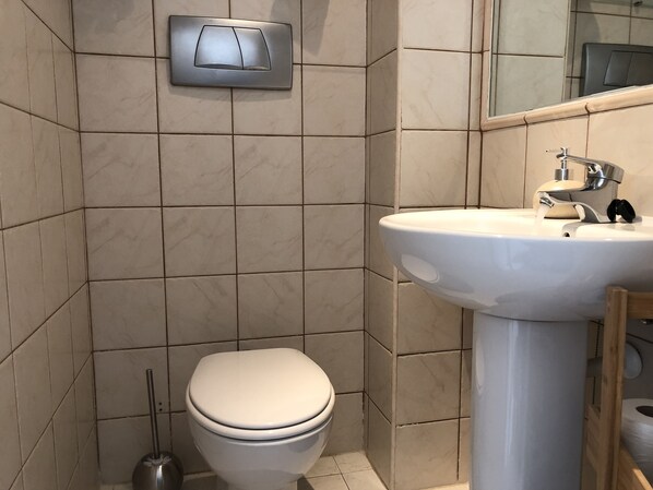 A bathroom with a toilet, a sink, and a mirror. - Uniquely situated Holiday Bungalow in Calpe, Spain. 2 Bedrooms, 1 Bathroom (Calp)
