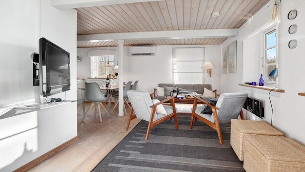 A modern living room with a dining area, wooden ceiling, and a fireplace. - Lovely home in Svaneke with WiFi (Svaneke)