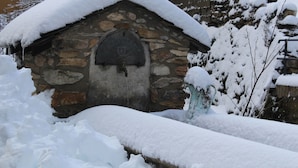 A stone building with a snow-covered roof and a door with a coat of arms. - In the heart of a preserved, welcoming, flower-filled mountain village (La Fajolle)