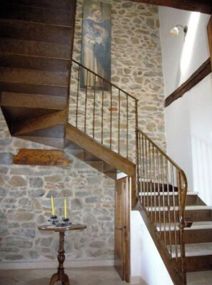 A staircase with stone walls and wooden railings.