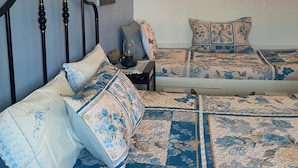 Un dormitorio con cama, mesita de noche, lámpara de pared y decoración mural.