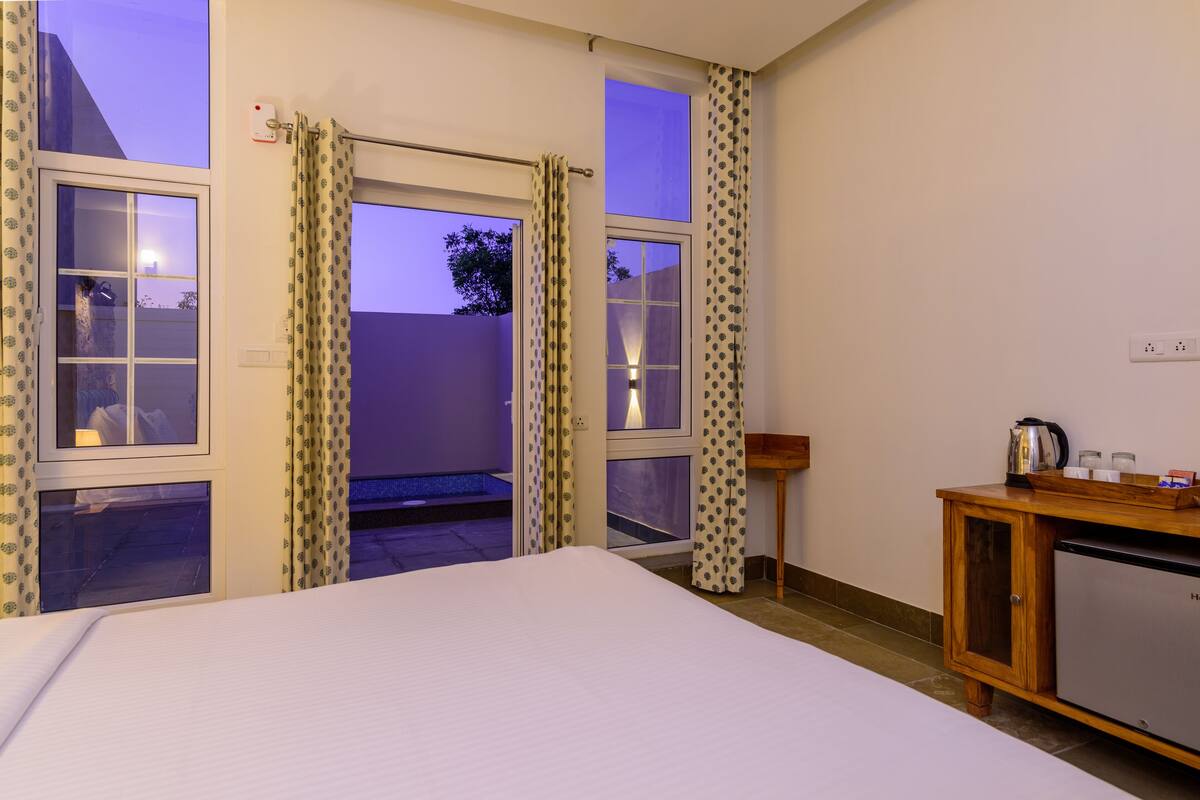 Ein Hotelzimmer mit Bett, Holzschrank und Blick ins Freie.