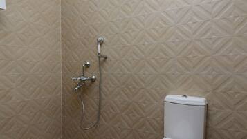 Une salle de bain avec douche, toilettes et carrelage décoratif.