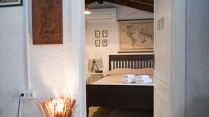 Een slaapkamer met een bed, een kaart aan de muur en een lamp op een nachtkastje.