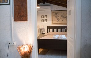 A bedroom with a bed, a map on the wall, and a lamp on a bedside table. - Amazing home in Posedarje (Posedarje)