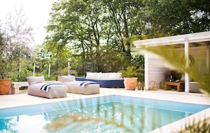 A poolside area with lounge chairs, a small table, and a covered seating area. - Amazing home in Posedarje (Posedarje)