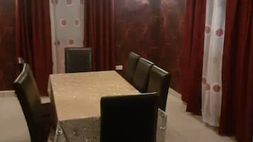 A dining area with a rectangular table, six chairs, and a chandelier.