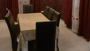 Et spiseområde med et rektangulært bord, seks stole og en lysekrone.