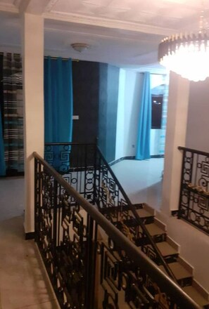 A staircase with black metal railings and a chandelier.