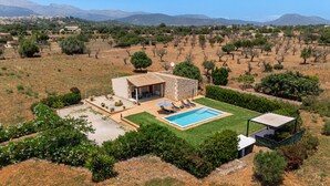 Una villa con piscina, mobiliario exterior y vistas del paisaje circundante.