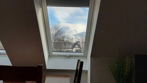A skylight window with a view of a snow-covered mountain and a building. - Taorbeag at Taormina (Fort William)