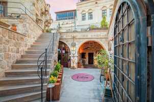 Un edificio de piedra con una escalera, una zona de recepción y un logotipo circular en el suelo.