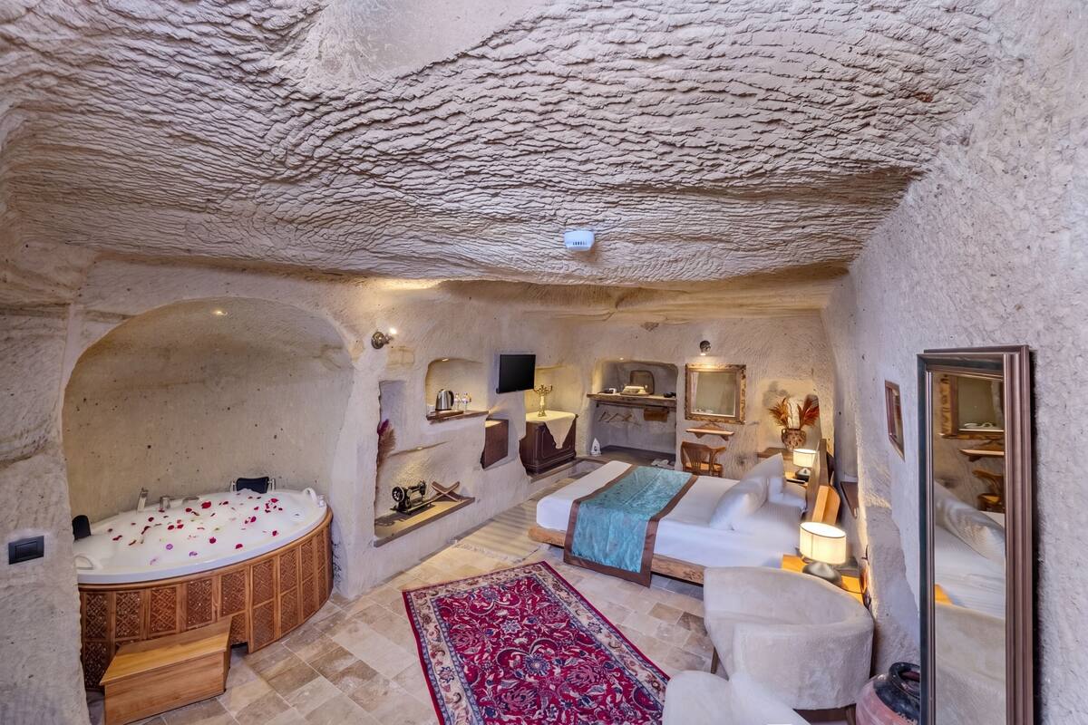 Ein Zimmer mit Badewanne, Bett, Sofa und Teppich.