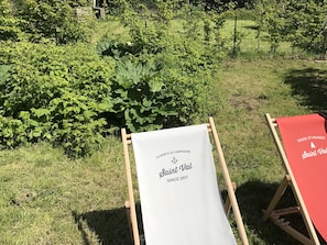 Un espace extérieur aménagé avec des sièges, une banderole sur laquelle on peut lire « Saint Val depuis 2017 » et une nappe rouge.