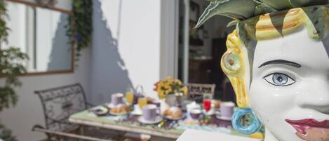 Et spisebord med forskellige ting, heriblandt en vase med blomster, en tepotte og en kop.