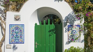 A white building with a green door, a tiled wall, and a small balcony with a railing. - Casa del Fico Dimora storica Positano (Positano)