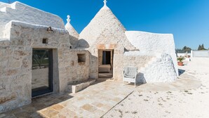 A stone building with a conical roof, a doorway, and a small window.