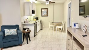 A compact living space with a kitchenette, a dining area, and a seating area with a sofa and chairs. -  Spacious 1-bedroom just mins to  WEF  (Wellington)