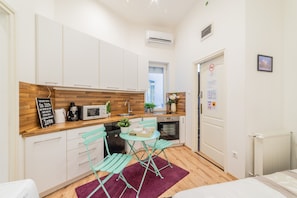 Apartamento básico | Cozinha privada | Geladeira, cadeirão de bebê, mesas de jantar