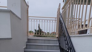 A staircase with a black railing leading to a balcony. - Beautiful Modern Apartment in Lefkada, Greece (Lefkada)