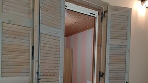 A room with a bed, a nightstand, and a lamp. - Beautiful Modern Apartment in Lefkada, Greece (Lefkada)