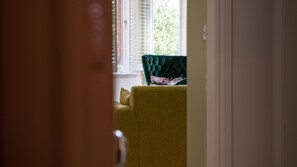 Ein Zimmer mit einem gelben Sessel und einem grünen Polsterstuhl.