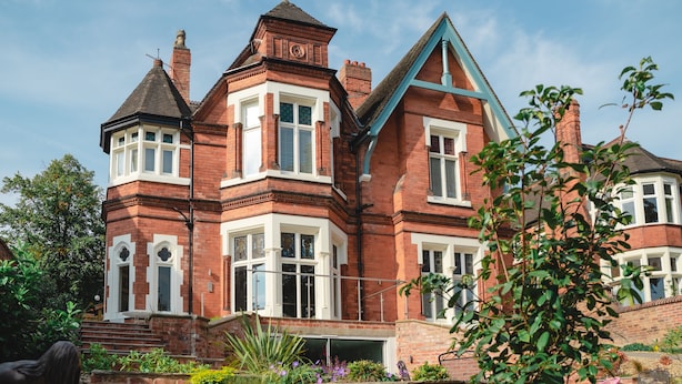 A large, red-brick Victorian-style house with multiple chimneys, white-framed windows, and a prominent tower. - Stunning upstairs flat in The Park neighbourhood (Nottingham)