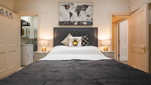 A bedroom with a large bed, two bedside lamps, a world map artwork above the bed, and a wardrobe with a mirror. - Stunning upstairs flat in The Park neighbourhood (Nottingham)
