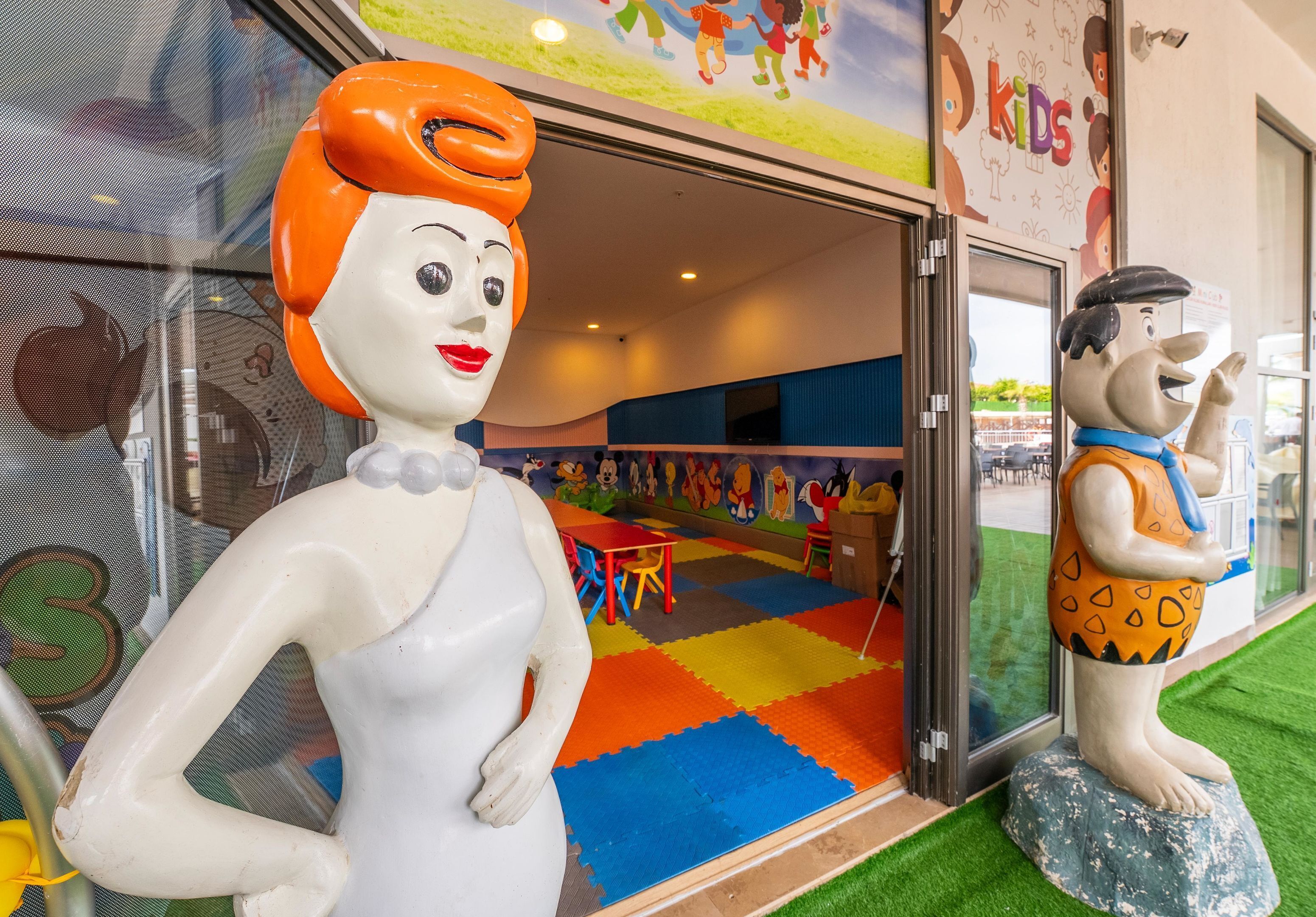 A children's play area with colorful flooring and cartoon-themed decorations.