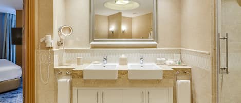 A modern bathroom with two sinks, a large mirror, and a shower area.