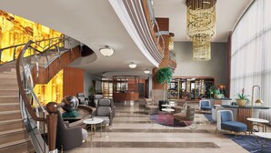 A spacious lobby with a modern staircase, seating areas, and a reception desk. - Divan Ankara (Ankara)