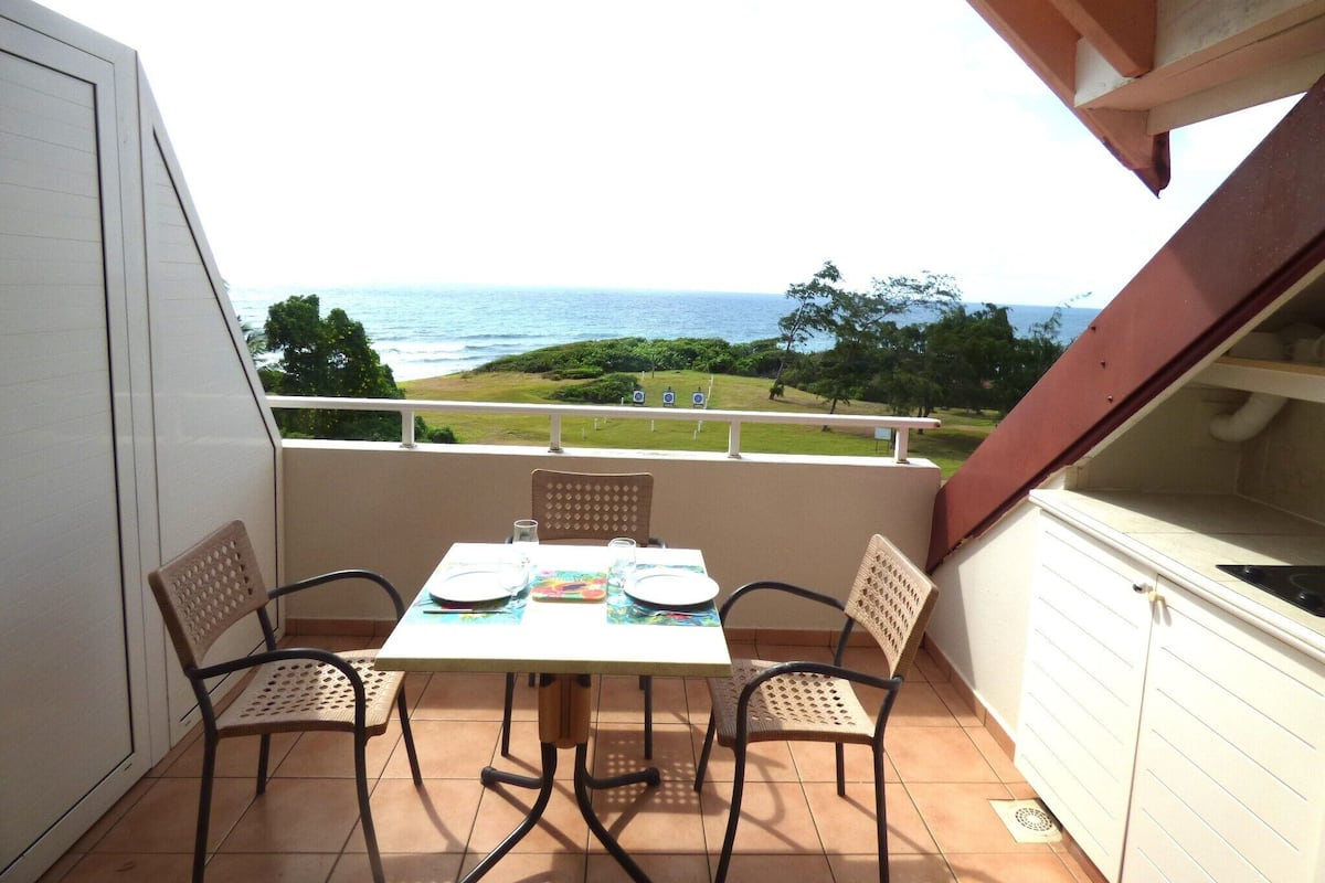 Ein Balkon mit einem Tisch für zwei Personen, mit Blick auf die Küste.