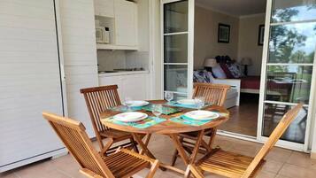 A dining area with a round wooden table set for four, surrounded by wooden chairs.