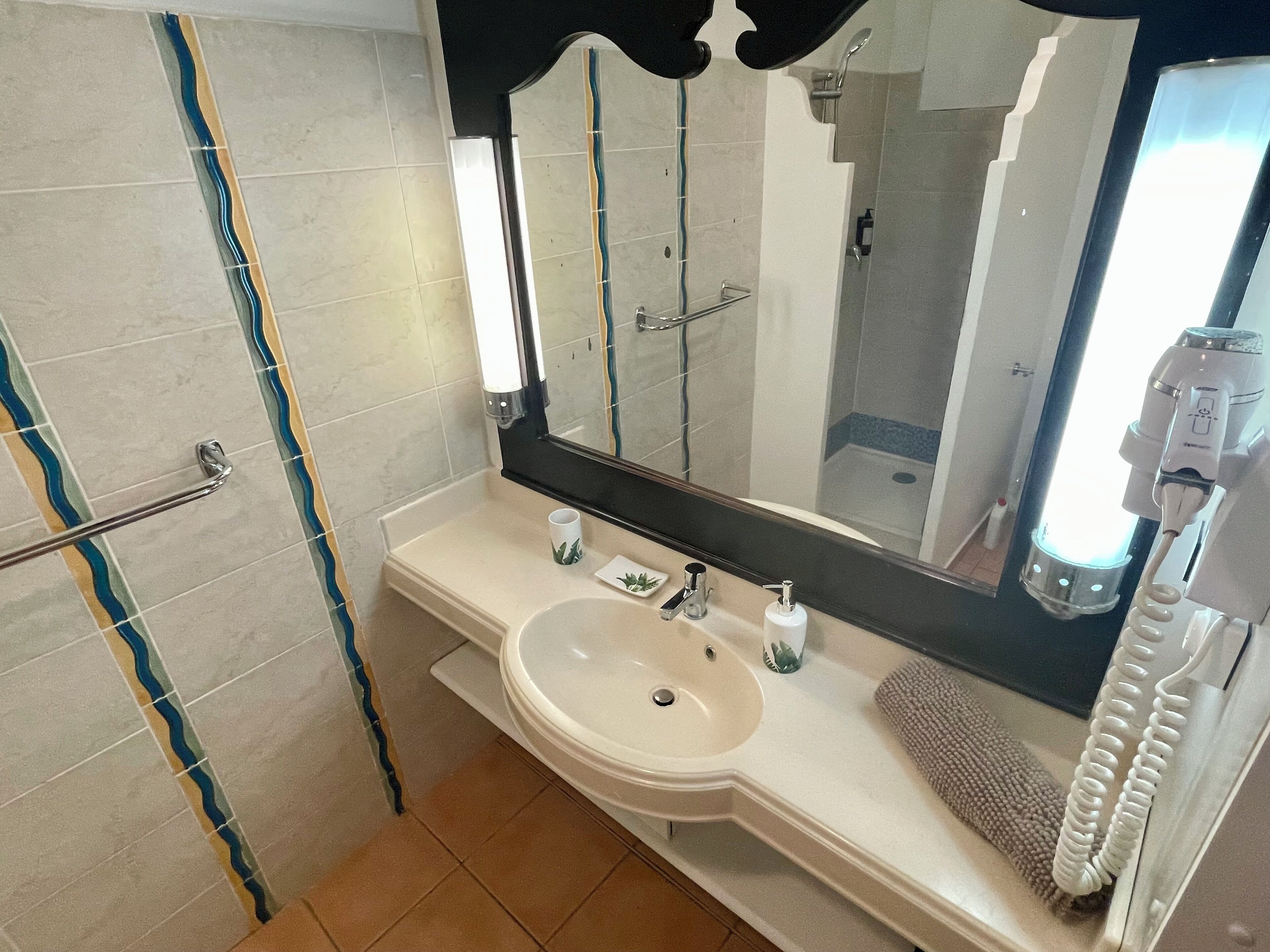 Ein Badezimmer mit Waschbecken, Spiegel und Handtuchhalter.