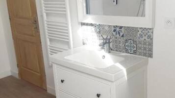 A white bathroom vanity with a mirror, a sink, and two drawers.