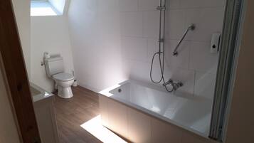 A modern bathroom with a toilet, a bathtub, and a shower.