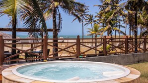A hot tub with a view of the beach and palm trees. - Atlantic Palace Family inn (Aquiraz)