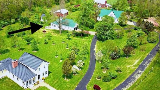 A large estate with multiple buildings, a winding driveway, and well-maintained lawns.