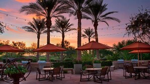 An outdoor patio with tables and chairs, string lights, and umbrellas. - Marriott Canyon Villas One Bedroom One room Full Kitchen Sleeps Four (Phoenix)
