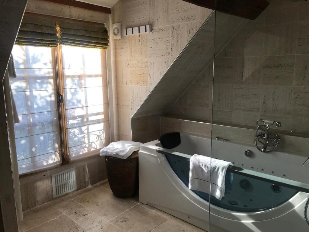Une salle de bain moderne avec une baignoire sur pieds, une fenêtre offrant une belle vue et un espace douche.