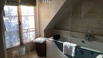 Une salle de bain moderne avec une baignoire sur pieds, une fenêtre offrant une belle vue et un espace douche.