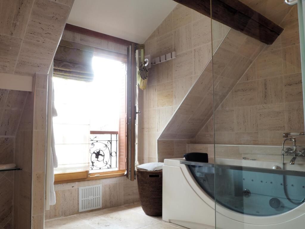 A modern bathroom with a freestanding bathtub, a window with a view, and a built-in washing machine.