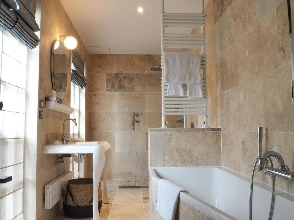 Een moderne badkamer met een wastafel, spiegel en bad.
