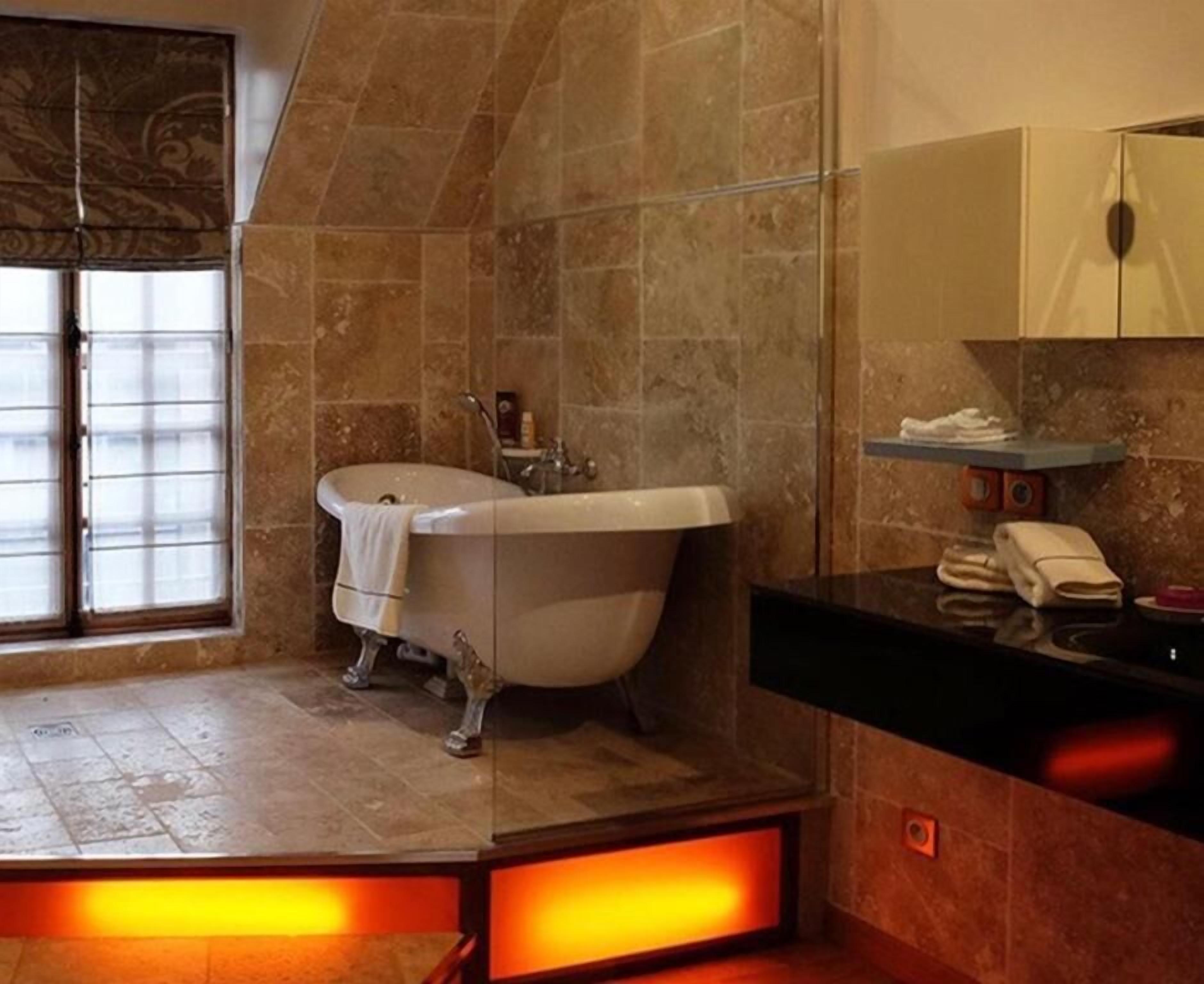 A bathroom with a freestanding bathtub, a vanity with a mirror, and a towel rack.