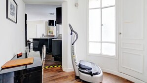 Een moderne keuken met een eethoek, een groot raam en een robotstofzuiger.